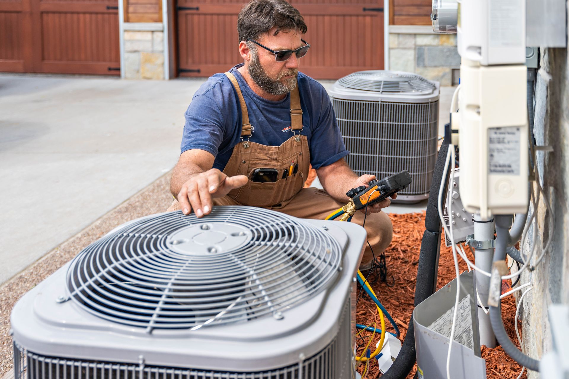 A man holding his hand over an air conditioning unit with a tester in other hand