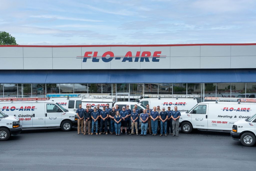 A company photo of technician's standing in front of work vehicles at the Flo-Aire Heating & Cooling office