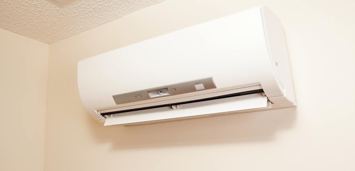 A ductless mini-split air conditioning unit mounted in a white wall